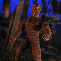 Mego 8-inch retro mummy figure wrapped in textured brown bandages posed in eerie, dark outdoor setting