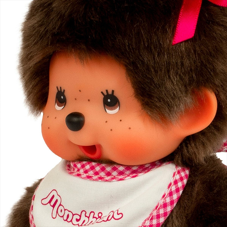 Sekiguchi Monchhichi Classic plush with brown fur, pink bows, and white and pink gingham bib close-up portrait