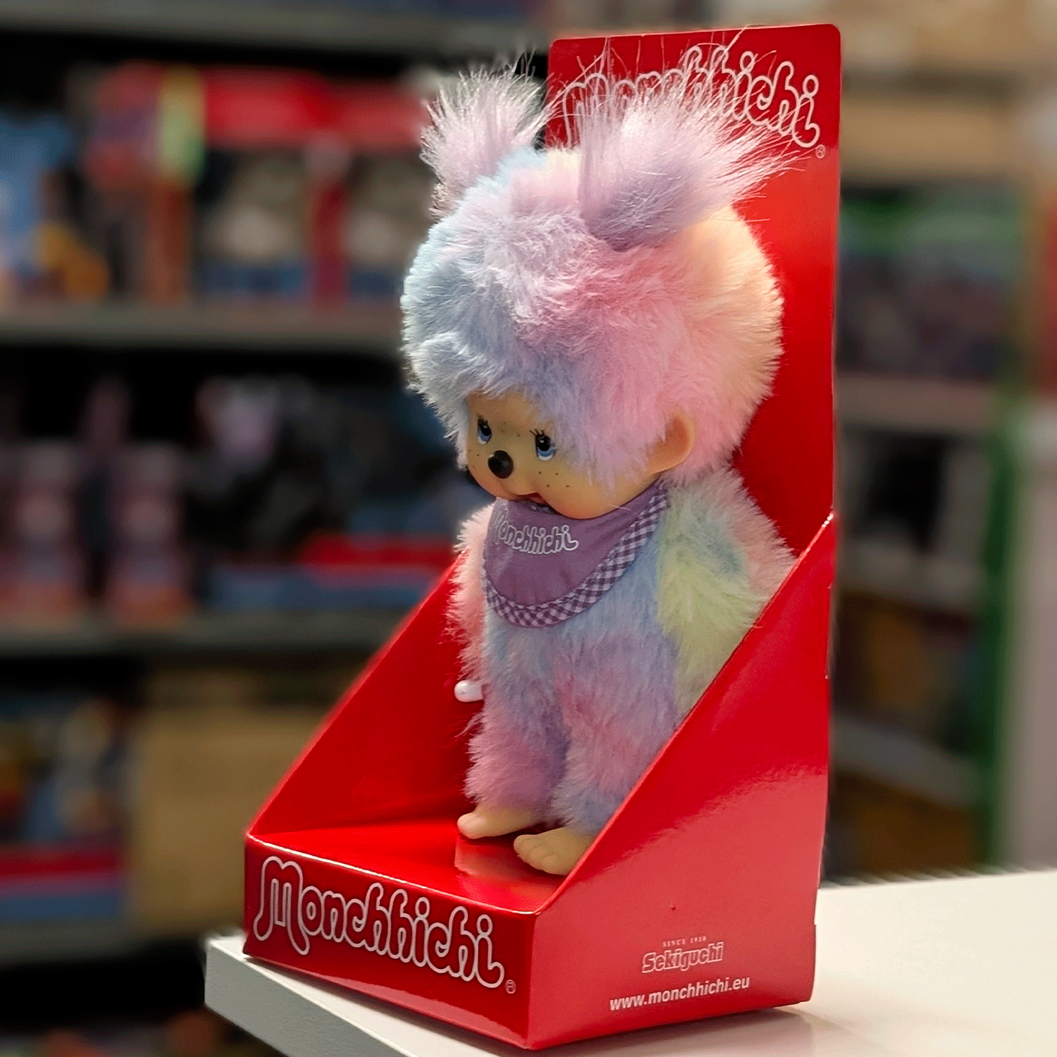 Sekiguchi 8-inch Monchhichi girl plush doll in pastel tie-dye fur with purple bib in red branded box