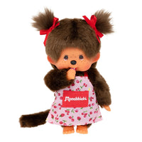 Sekiguchi Monchhichi Girl plush doll wearing pink flower apron with red bows and thumb in mouth, 8 inches tall