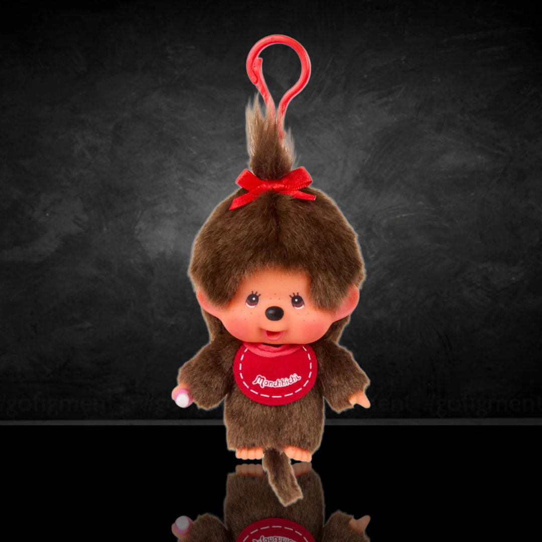 Sekiguchi Monchhichi Girl plush keychain with red bow and pink bib, soft and collectible miniature mascot clip.