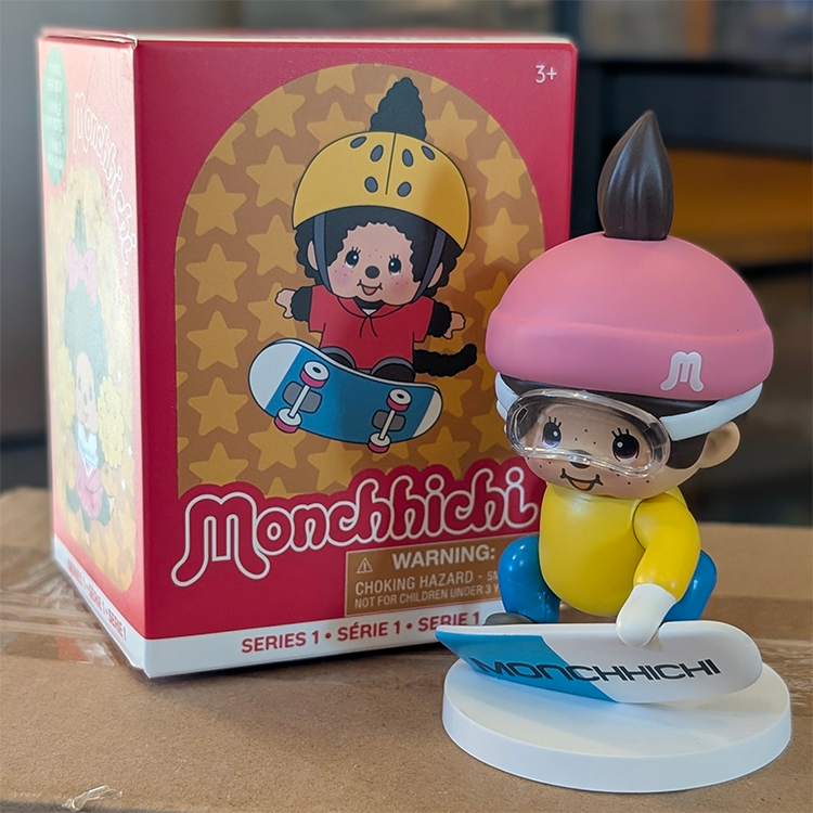 Sekiguchi Monchhichi boy snowboarding vinyl figure with pink helmet and blue snowboard on white base