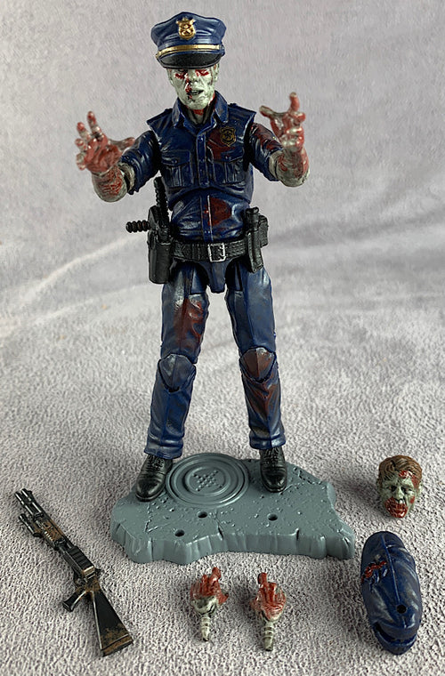 Zombie police officer action figure with accessories on a gray background