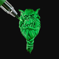 Green dragon-shaped bottle stopper with a metallic tool on a white background