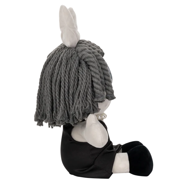 Glitch Ragatha Noir plush doll sitting sideways with gray yarn hair, pearl necklace, black dress, and white ears