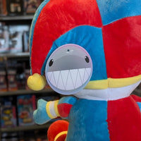 Close-up of Glitch Pomni Plush jester hat and smiling face tag on colorful 11 inch soft toy from The Amazing Digital Circus