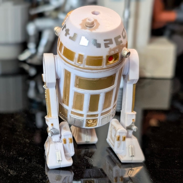 Kenner R6-D3 Star Wars Droid Factory action figure with gold accents and articulated parts on black surface