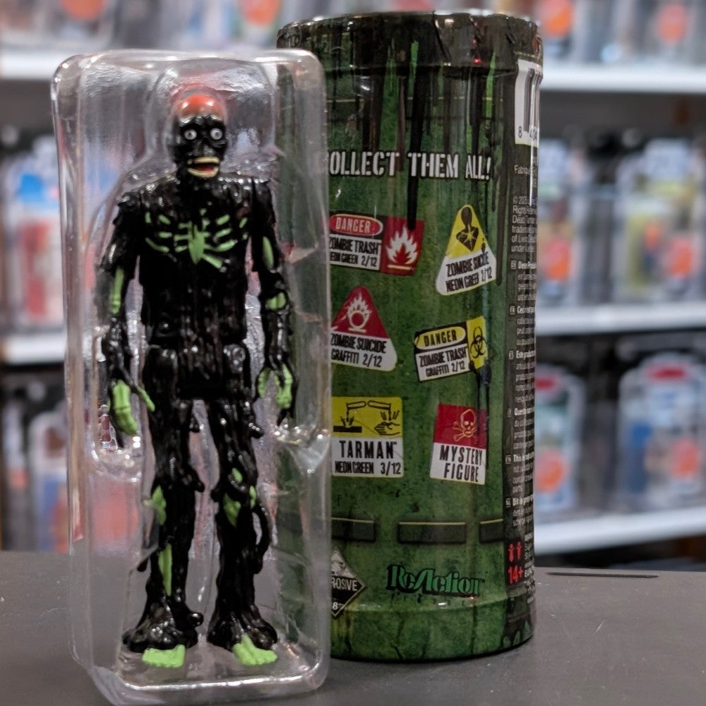 Super7 neon green tar-covered Tarman zombie figure with glowing skeletal details in protective clear plastic case