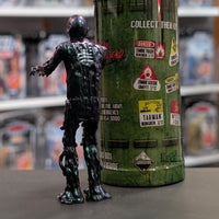Super7 metallic blue tar-covered Tarman zombie figure viewed from back with green collectible container in background