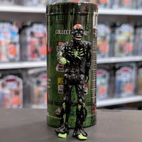 Super7 black tar-covered Tarman zombie figure with glowing green skeletal details standing in front of collectible container
