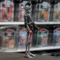 Super7 metallic blue graffiti styled male zombie figure with skeletal face, mohawk, black jacket, and chained accessories standing upright