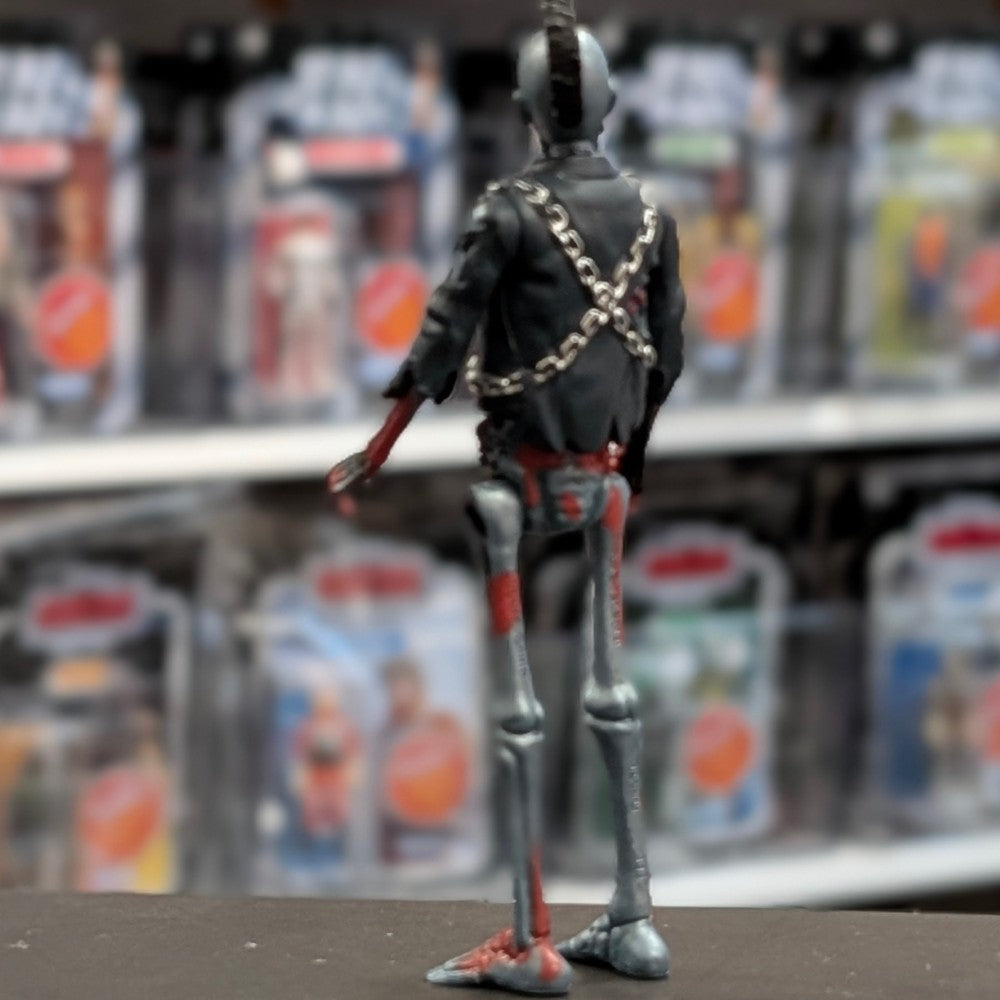 Super7 metallic blue graffiti male zombie figure with skeletal back, chains wrapped around black jacket standing on display