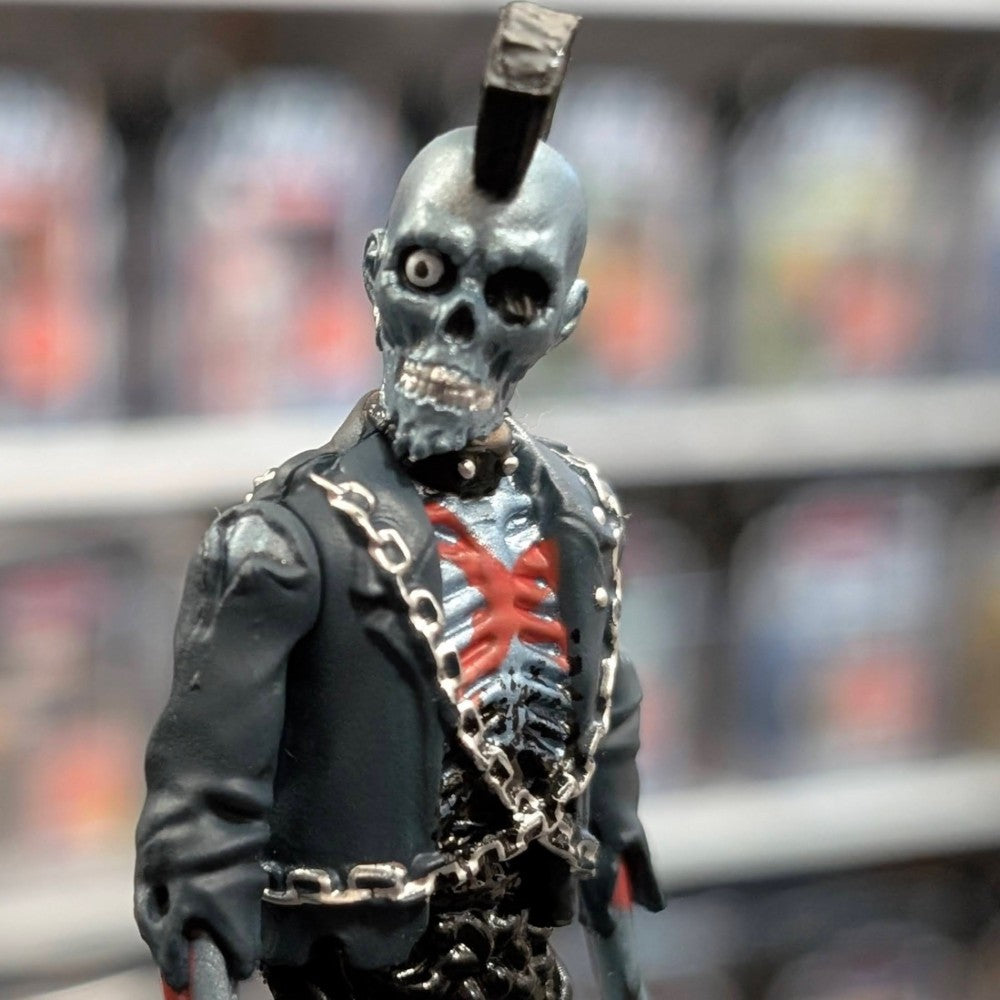 Super7 metallic blue graffiti male zombie figure with mohawk, exposed red and black skeletal chest, wearing black jacket and chains