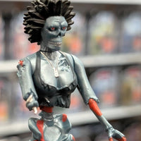 Super7 metallic blue graffiti female zombie figure with spiked hair and red eyes posed in store display setting