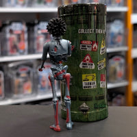Super7 metallic blue graffiti female zombie figure with spiked hair shown from behind near collectible tube