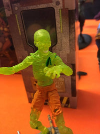 Toy figure with glowing green skin on an orange surface