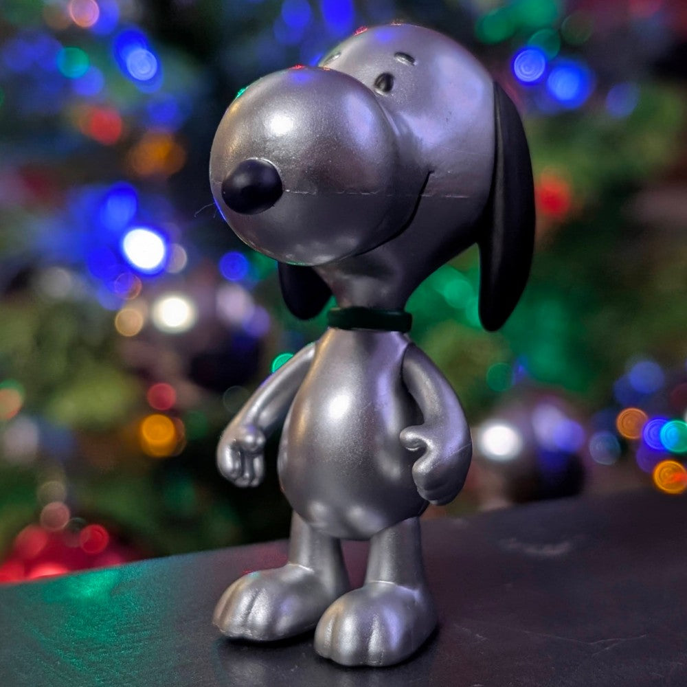 Silver metallic Snoopy figure by Super7 from Holiday Blind Box Wave 8 with festive blurred background lighting