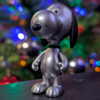Silver metallic Snoopy figure by Super7 from Holiday Blind Box Wave 8 with festive blurred background lighting