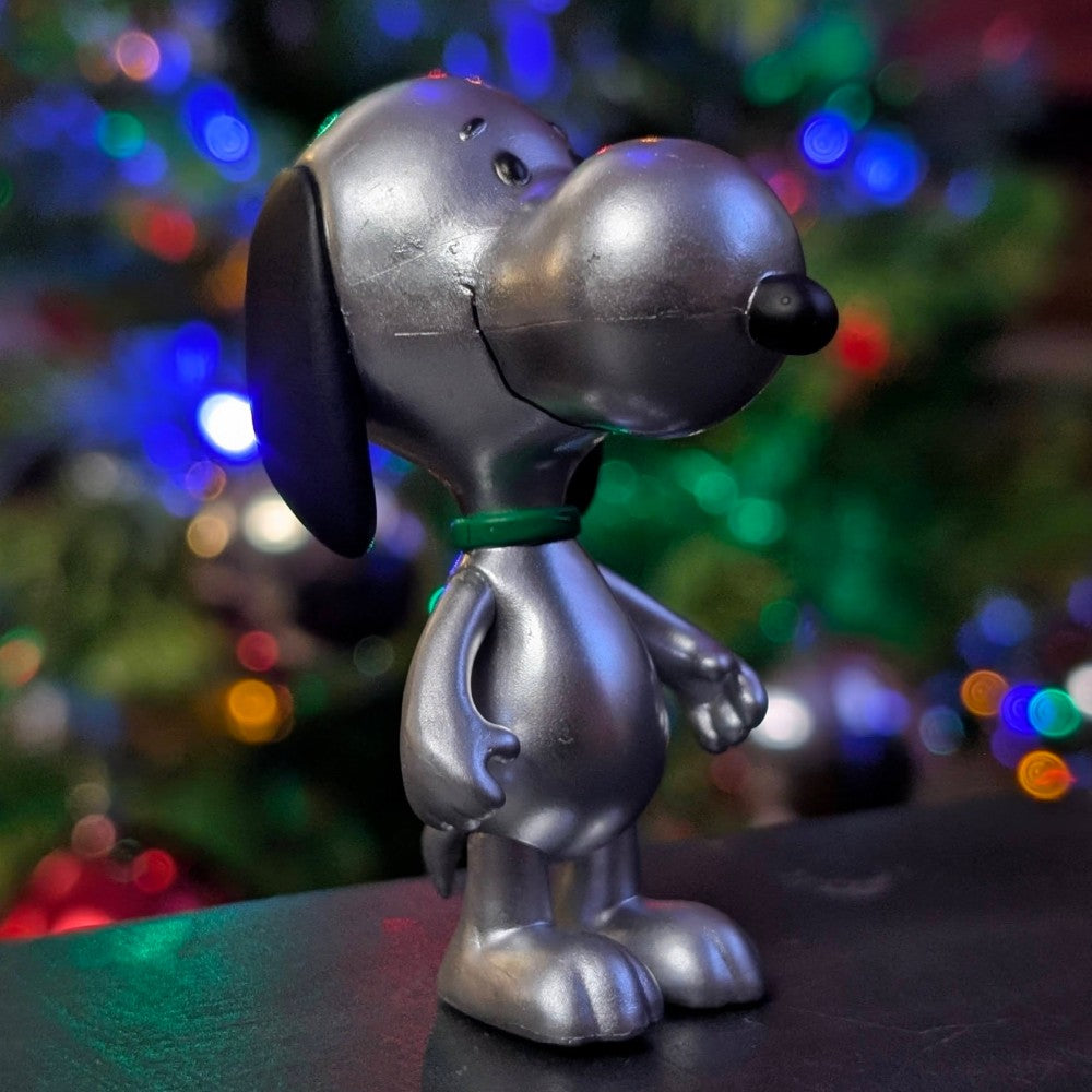 Super7 Silver Snoopy Holiday ReAction figure in metallic finish with festive blurred lights background