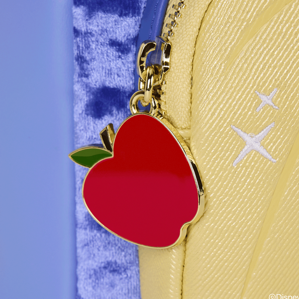 Loungefly mini backpack zipper pull featuring red apple charm with green leaf on yellow textured fabric side panel