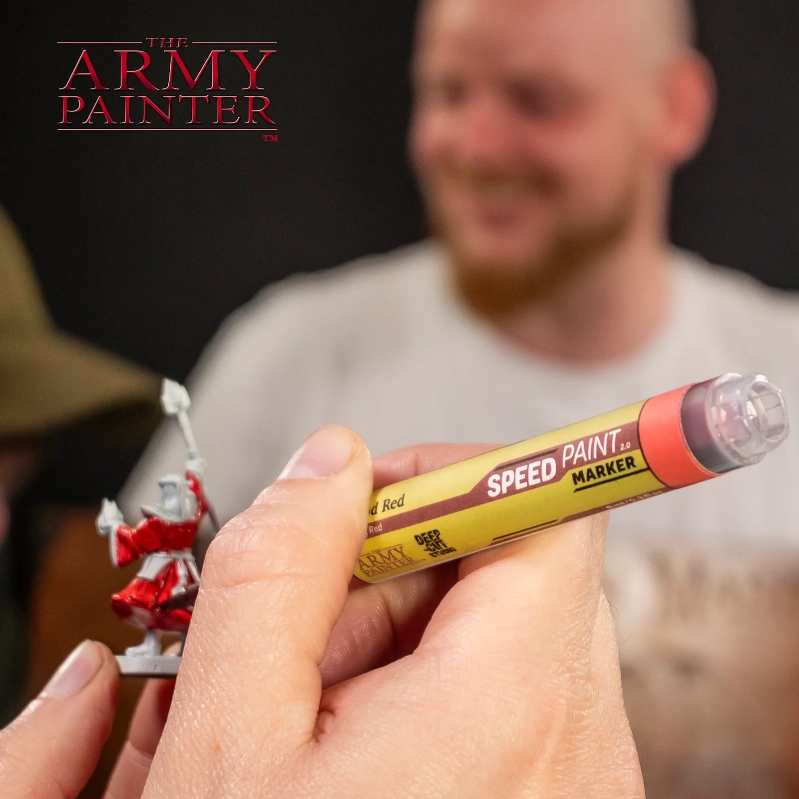 Orc Skin Army Painter Speedpaint Marker - One-Coat Miniature Paint SM1022P held close to red miniature figure for detailed painting