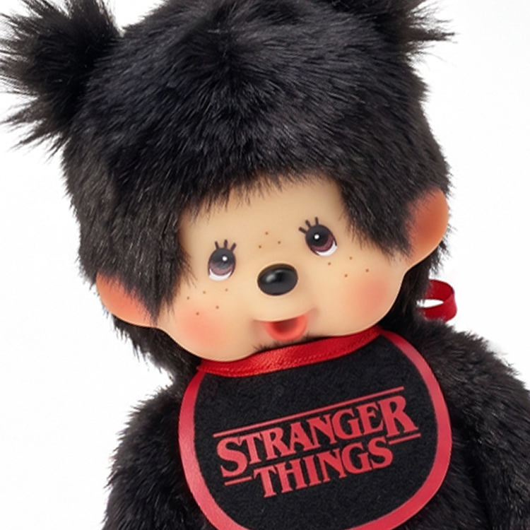 Black furry character with tufted hair, round eyes, and a red-trimmed bib reading Stranger Things