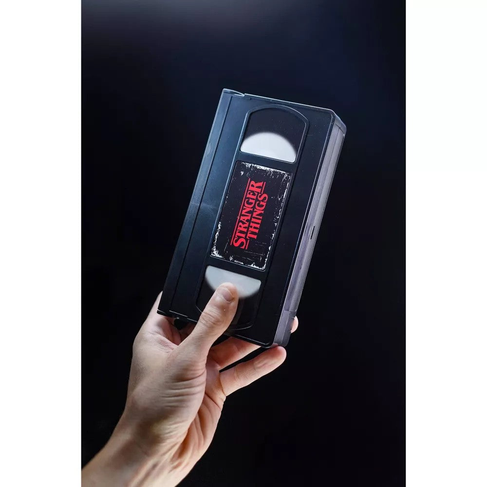 Hand holding a VHS tape labeled Stranger Things for the VHS Stars Stranger Things Eleven vs. Demogorgon Diorama Playset