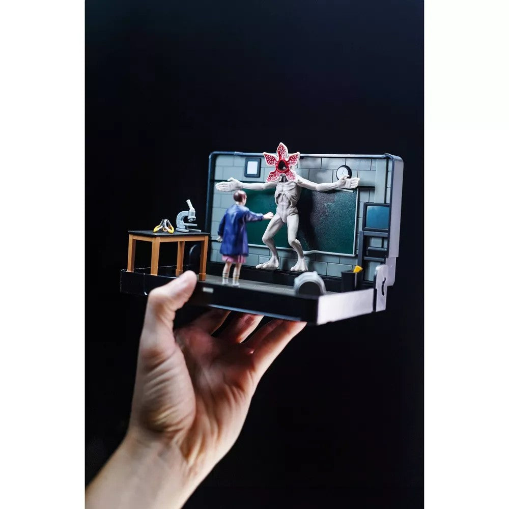Handheld VHS Stars Stranger Things Eleven vs. Demogorgon Diorama Playset by Console Heroes with detailed figures and lab setting.