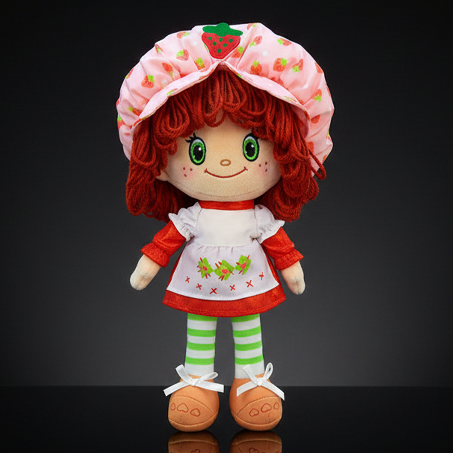 Strawberry Shortcake plush doll with soft yarn hair wearing pink bonnet and red dress by Loyal Subjects on black background