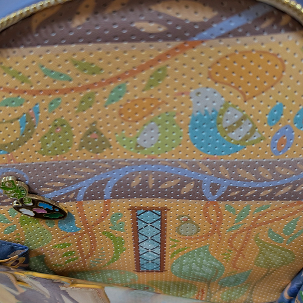 Disney Tangled 2026 Loungefly Cosplay Mini-Backpack In Hand showing colorful patterned interior with detailed zipper pull charm