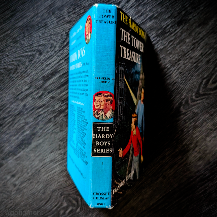 Vintage 1959 hardcover of The Tower Treasure Hardy Boys book with blue spine and Rudi Nappi cover art by Grosset & Dunlap