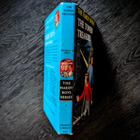 Vintage 1959 hardcover of The Tower Treasure Hardy Boys book with blue spine and Rudi Nappi cover art by Grosset & Dunlap