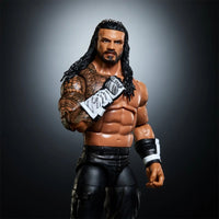 Muscular wrestler action figure with long dark hair, beard, tattoos, black pants, and white wrist wraps