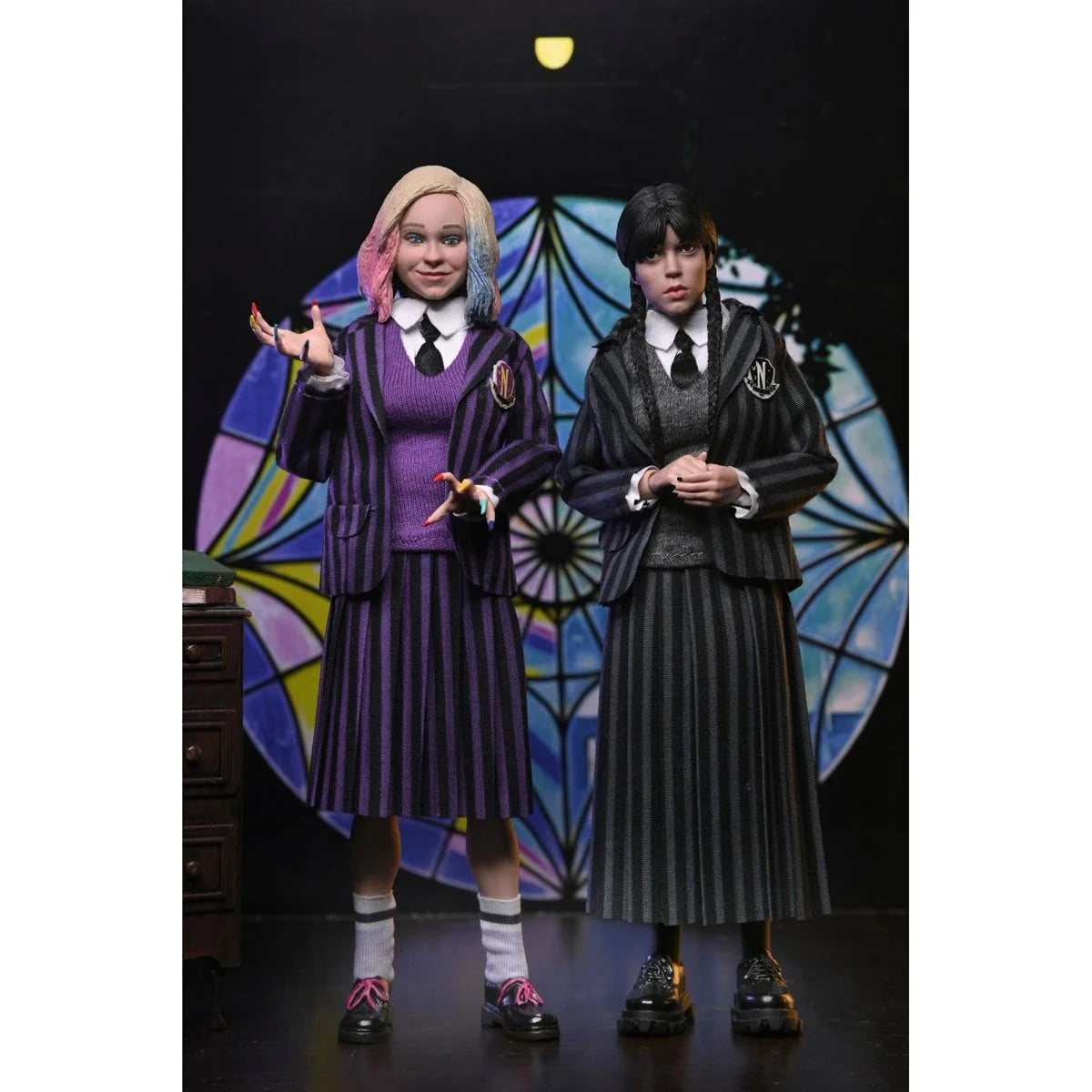 Wednesday and Enid 8-Inch Clothed Action Figure 2-Pack by NECA with detailed outfits and accessories in dark setting