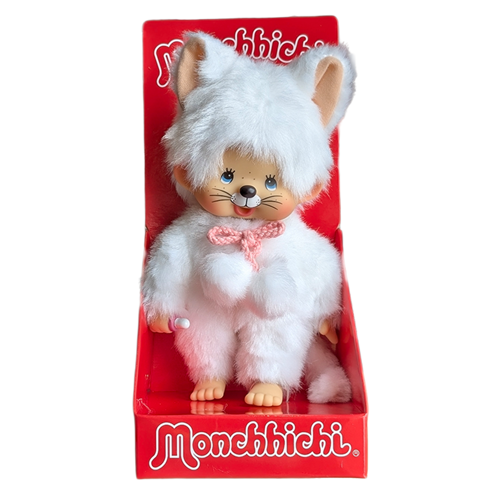 Monchhichi doll dressed in a white furry cat costume with pink bow, displayed in red Monchhichi branded packaging.