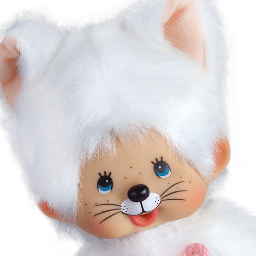 Close-up of a vintage plush doll with white fur, blue eyes, large ears, freckles, and a smiling face resembling a kitten.