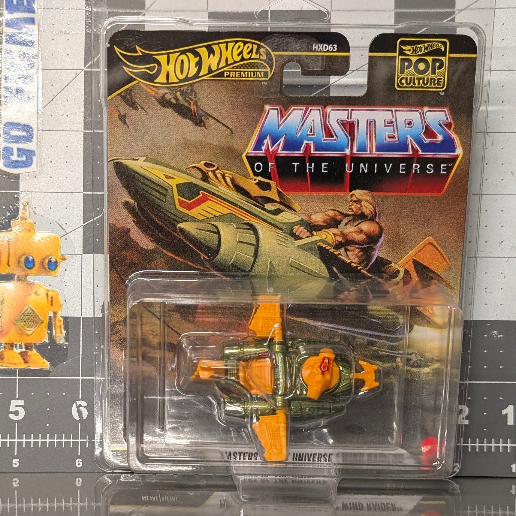 He-Man Masters of the Universe Wind Raider 1:64 Scale Hot Wheels Premium Pop Culture Diecast Car by Mattel in green and orange packaging