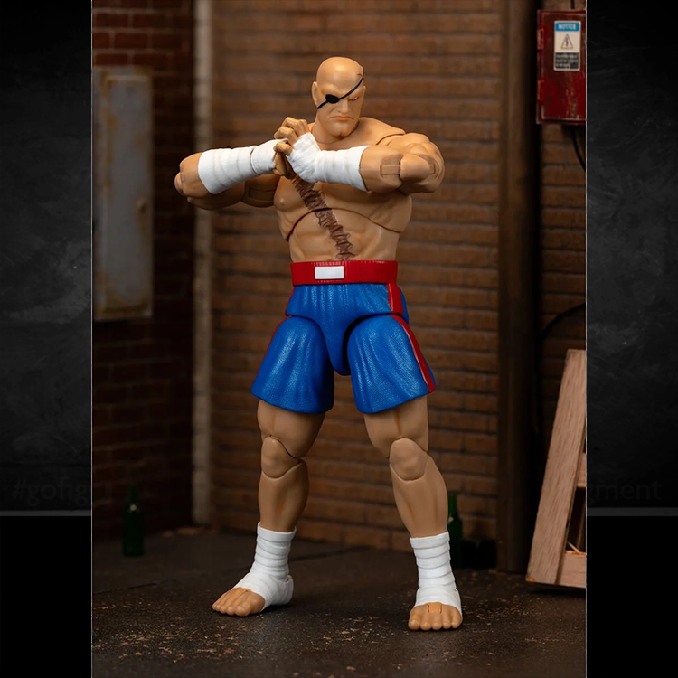 Jada Toys Ultra Street Fighter II Sagat action figure in blue shorts and wrap hands posed in industrial setting