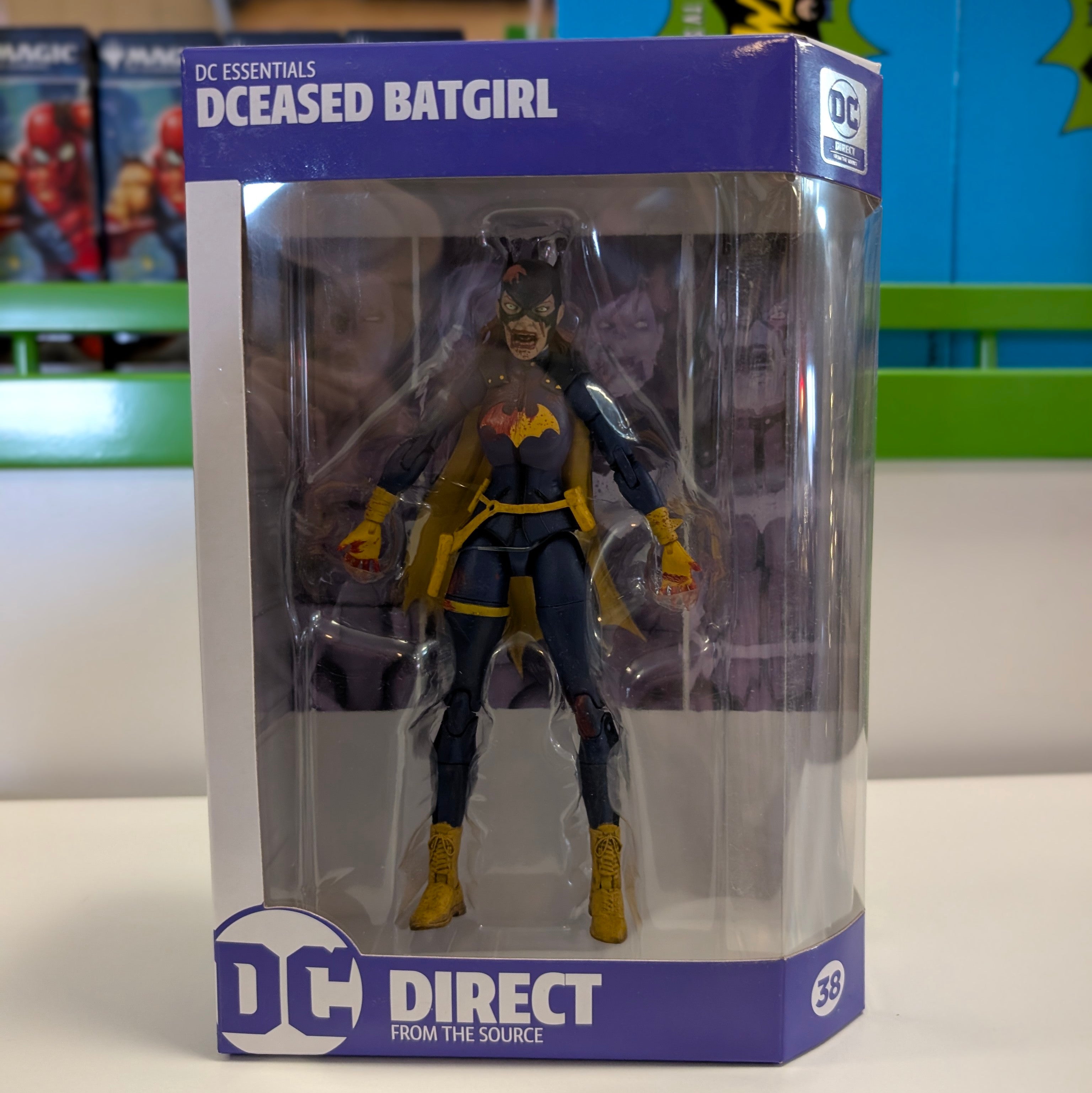 DC Direct DC Essentials DCeased Batgirl action figure in packaging with dark zombie design and yellow costume details
