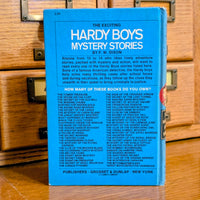 Back cover of the 1971 Hardy Boys book The Flickering Torch Mystery by Grosset & Dunlap Inc.