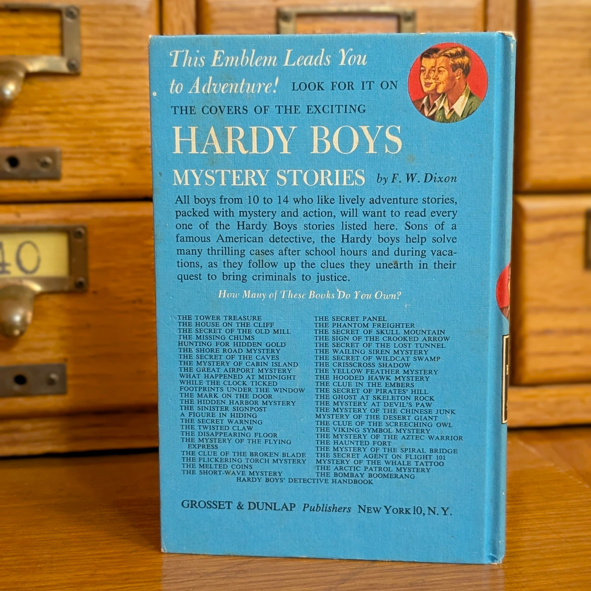 Back cover of vintage Hardy Boys book The Phantom Freighter by Grosset & Dunlap with list of titles and adventure details