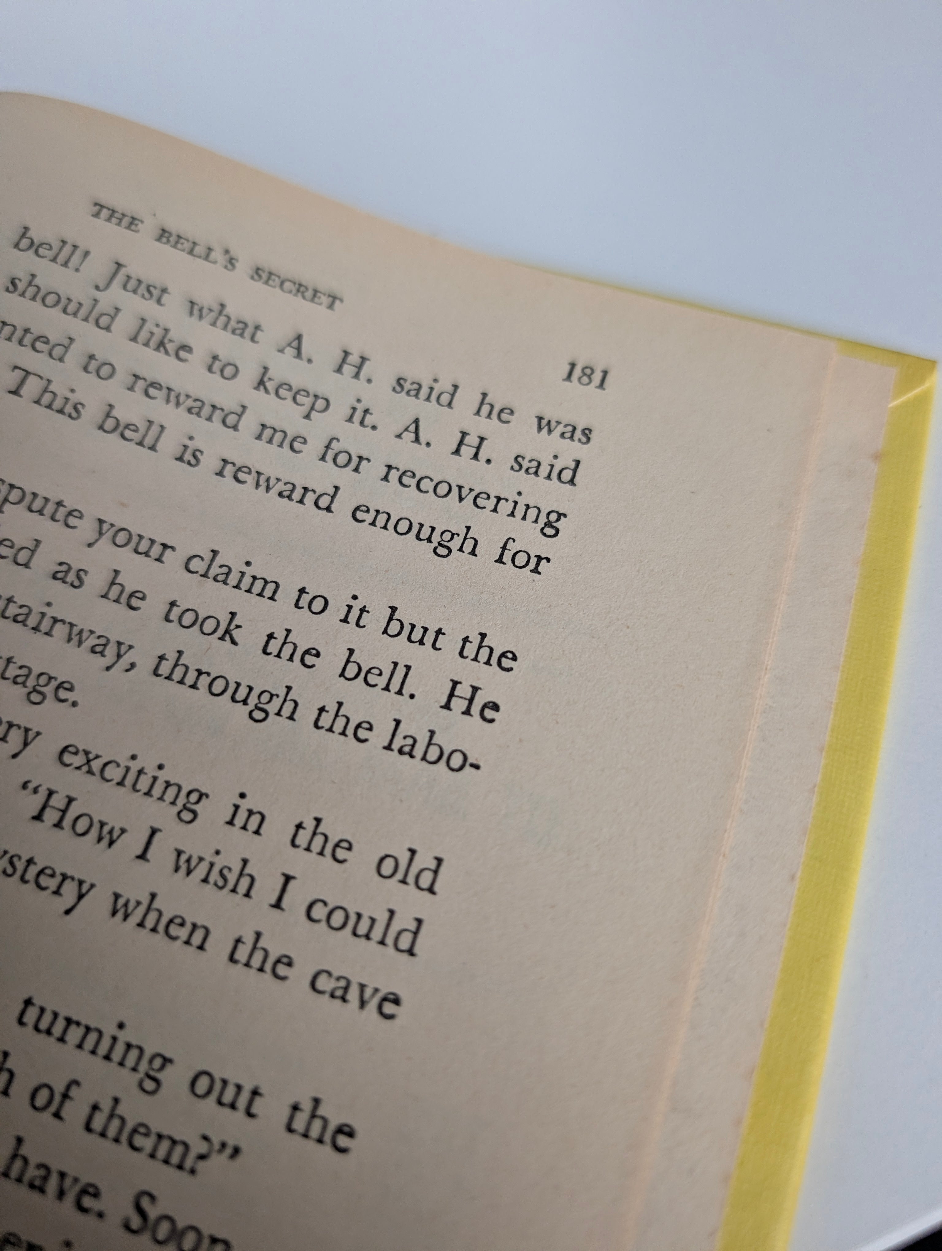 Close-up of page 181 from The Mystery of the Tolling Bell by Grosset & Dunlap Inc. with yellow book edge visible