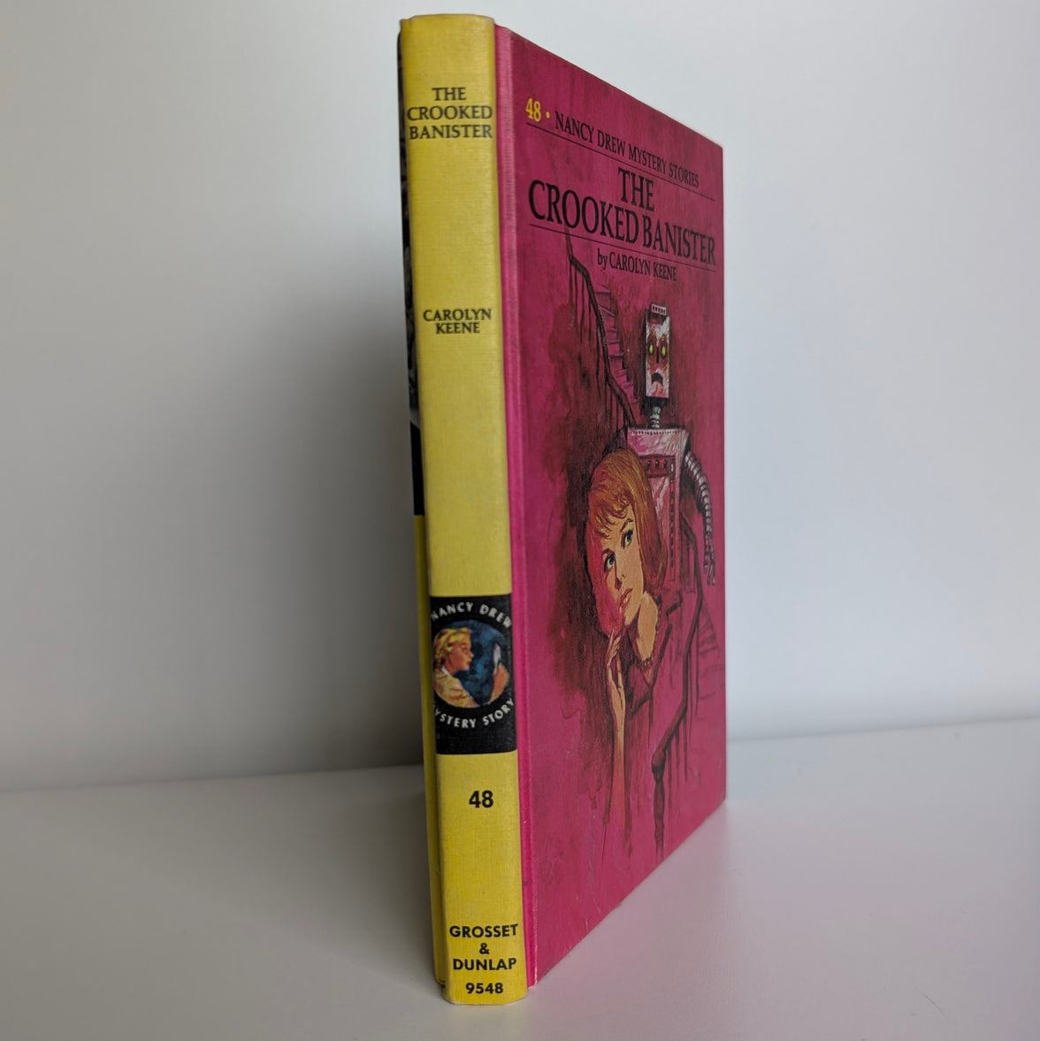 Vintage Nancy Drew Mystery Book 48 The Crooked Banister by Grosset & Dunlap with yellow spine and pink cover