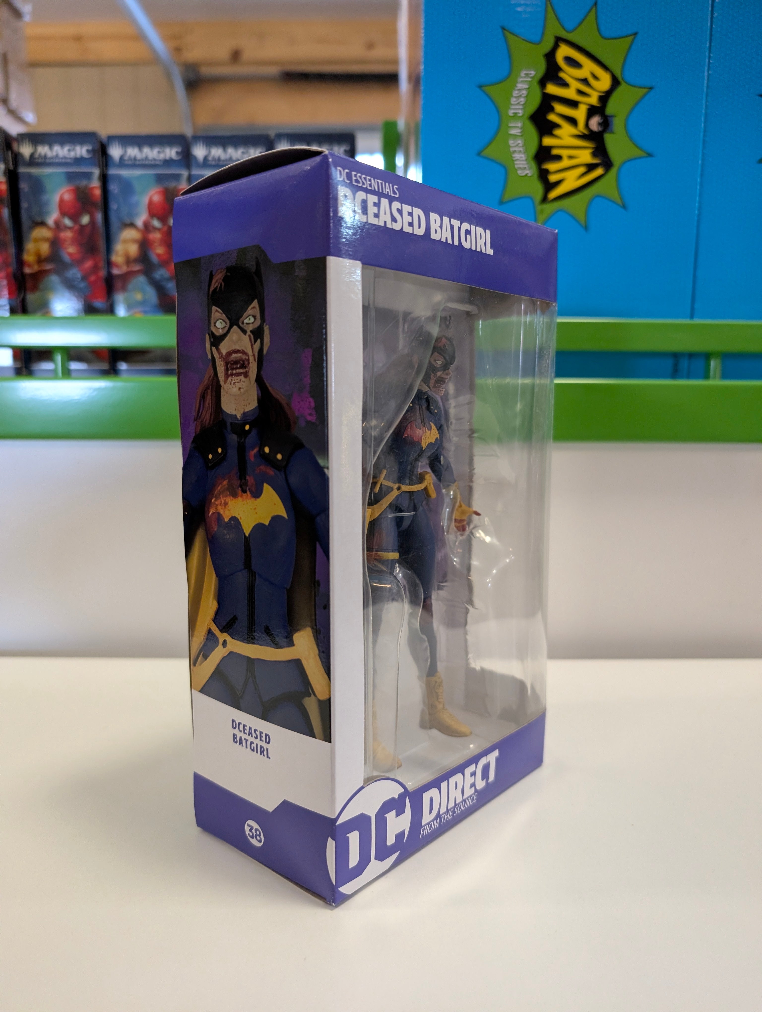 DC Direct DC Essentials DCeased Batgirl action figure in original purple and white packaging side view
