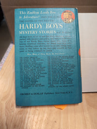 Vintage Hardy Boys book back cover listing titles by Grosset & Dunlap, Inc., blue background with small Hardy Boys portrait