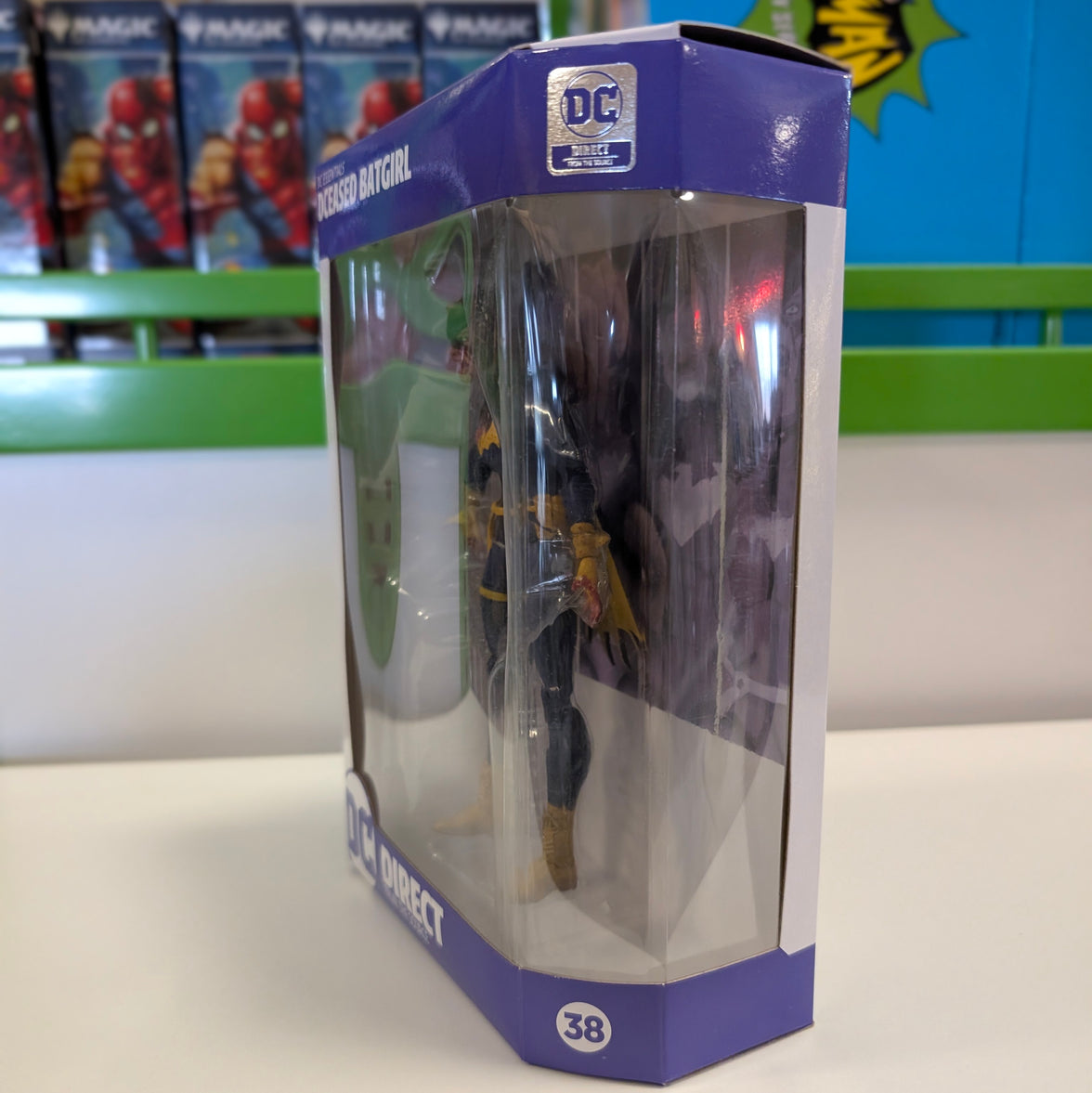 DC Direct DC Essentials DCeased Batgirl 6-inch action figure in window box side view with purple packaging