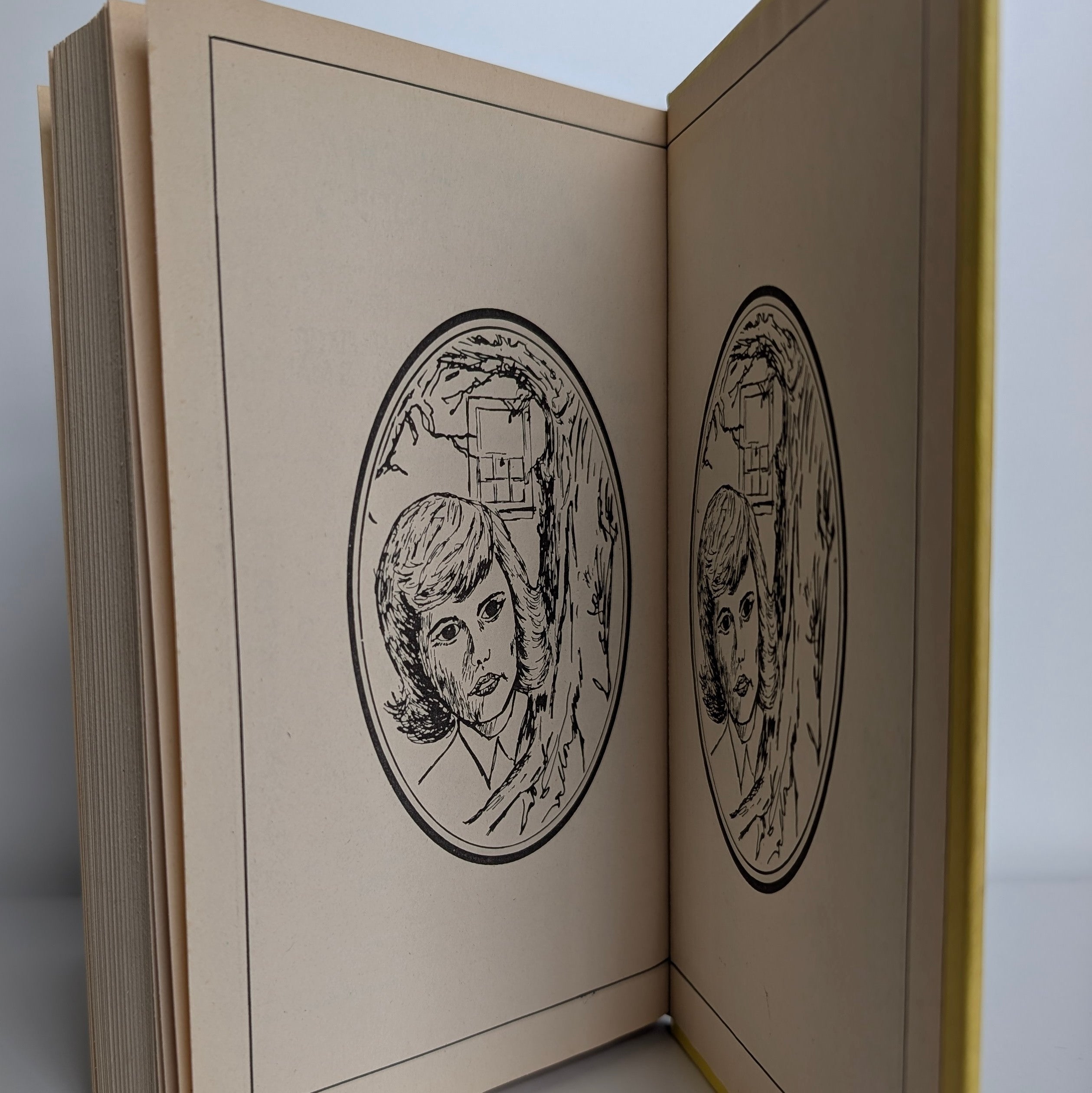 Open Nancy Drew book showing black and white cameo endpages illustration published by Grosset & Dunlap